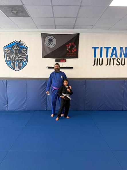Titan student celebrating a belt promotion with an instructor